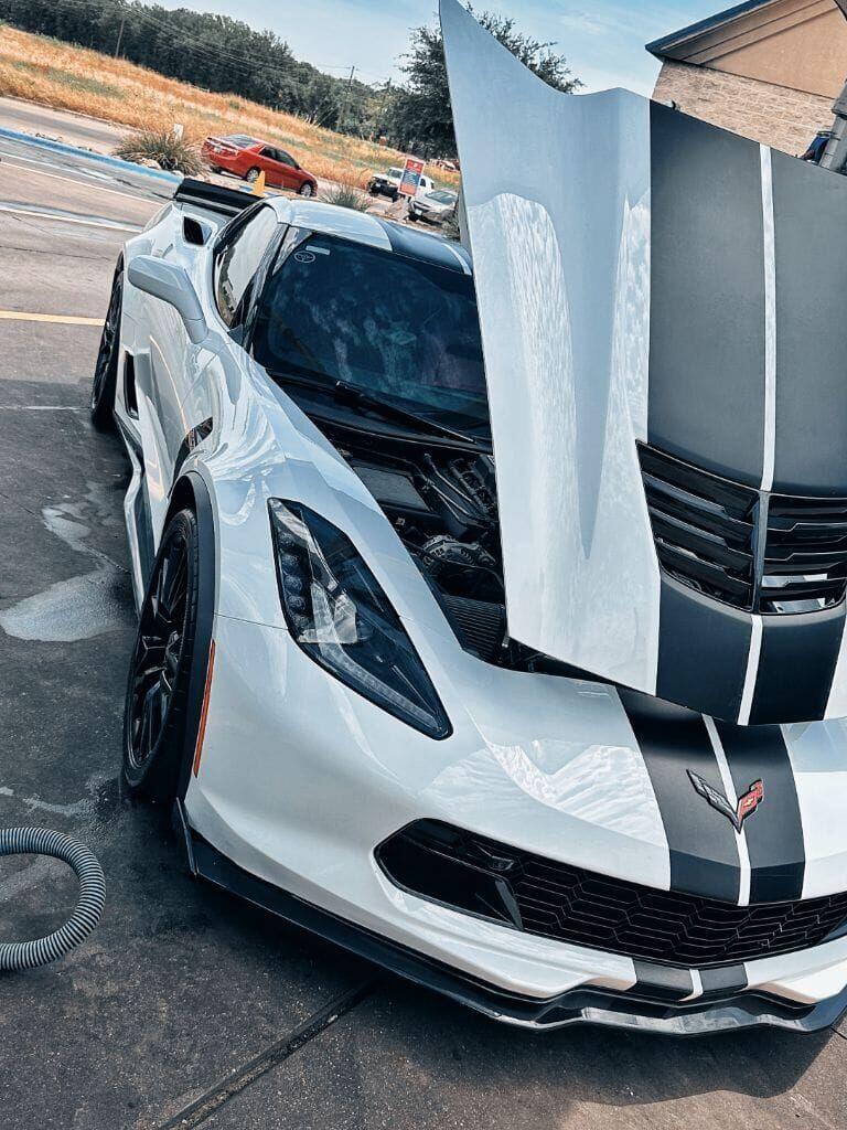 White Chevrolet Corvette Z06 with hood open showing a mirror-perfect paint correction at Brightworks Granbury